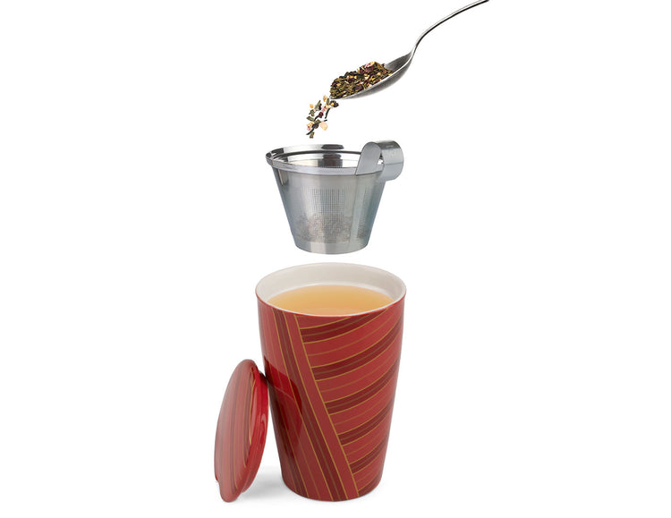 A red patterned KATI ceramic Steeping Cup with a matching lid, shown with tea poured into a metal infuser strainer above it. The mug is filled with tea, and the lid rests beside it, all on a clean white background.