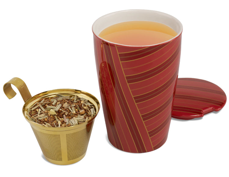A glossy, red striped, KATI Steeping Cup Warming Joy with a matching lid off showing steeped tea inside, and a gold metal infuser basket out front with loose tea inside