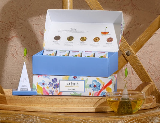 Volare Petite Presentation Box, open and closed boxes, stacked on a wooden chair with glass of tea and infuser.