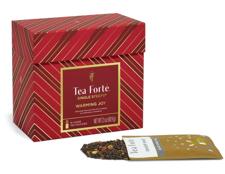 Warming Joy Single Steeps Sampler of 15 loose tea pouches, shown with one individual tea pouch and a small amount of loose tea spilling out on a white background.