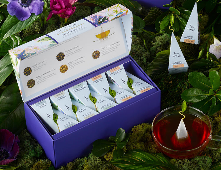 Demoiselle Presentation Box open with pyramids and teacup amongst moss