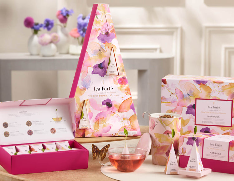 The Mariposa collection including the Mariposa 12 days of Blissful Teas box with teacups and and infuser next to it