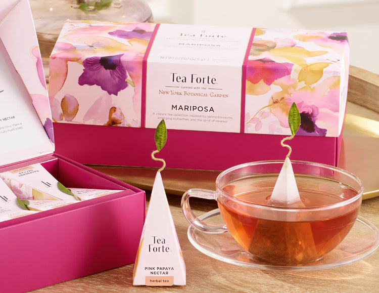 Mariposa Presentation Box of 20 pyramid tea infusers, closed  on a table with a tea infuser and pink tea tray