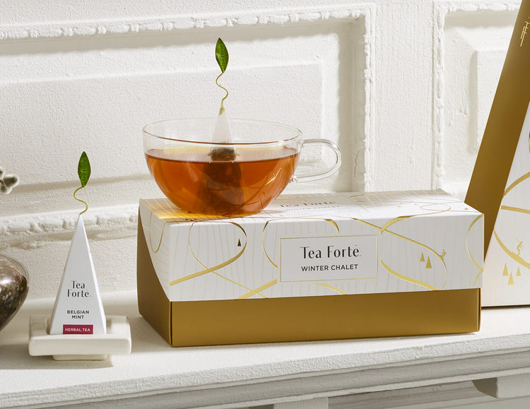 Presentation Box of Winter Chalet, closed, with a glass teacup and white tea tray